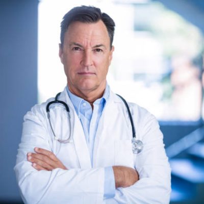 Portrait of doctors standing with arms crossed in hospital